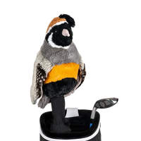 A quail-shaped golf club head cover sitting in a golf bag, with a club peeking out.