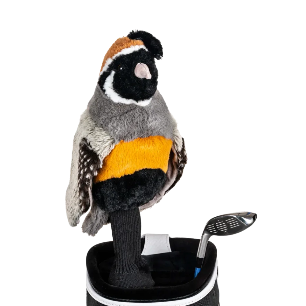 A quail-shaped golf club head cover sitting in a golf bag, with a club peeking out.