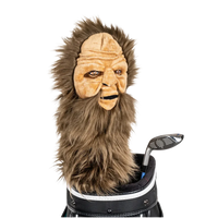 A Sasquatch-shaped golf club head cover sitting in a golf bag, with a club peeking out.