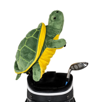 A turtle-shaped golf club head cover sitting in a golf bag, with a club peeking out.