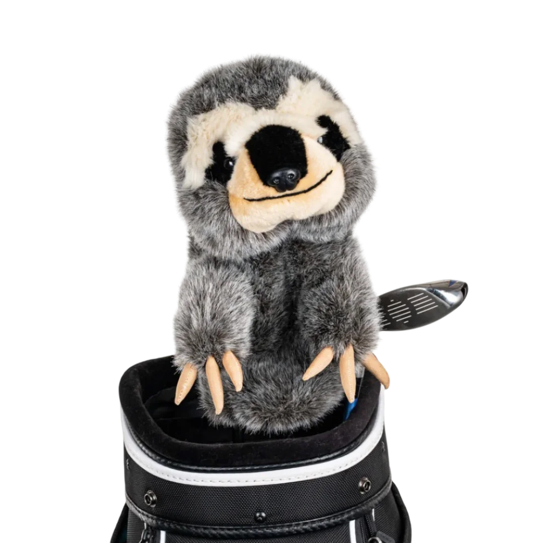 A sloth-shaped golf club head cover sitting in a golf bag, with a club peeking out.