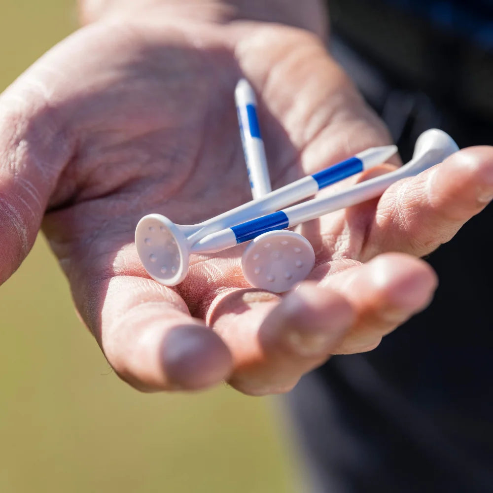 Hand holding golf tees with blue and white design