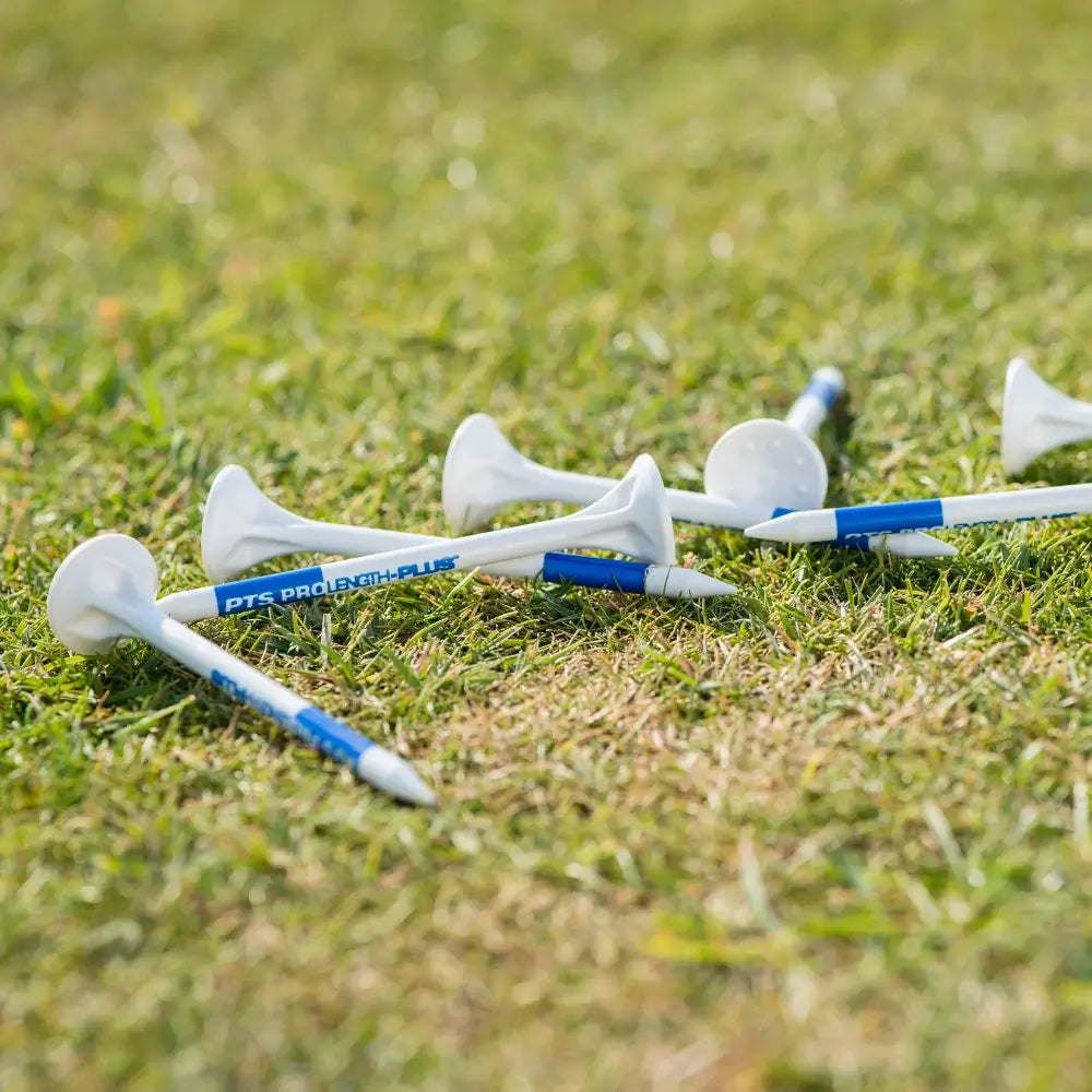 Golf tees with blue and white golf tees on a grassy surface