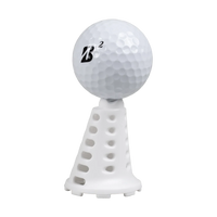 Golf ball resting on a white Pride Sports simulator tee.