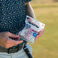 A person holding a package of special edition stars and stripes golf tees containing 45 tees that are 3 1/4 inches long.