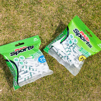 Two packages of pride sports golf tees on grass, featuring special edition designs with shamrocks and green stripes. One package contains 3 1/4" tees and the other contains 2 3/4" tees.
