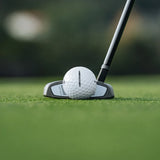 Golf ball and club on a green golf course