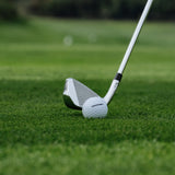 Golf club and ball on a green grass surface