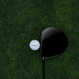 Golf club and golf ball on a green grass surface
