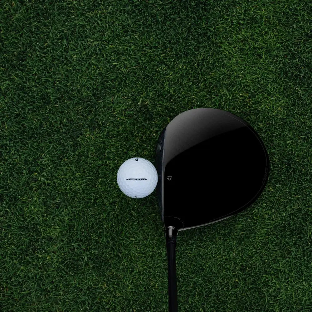 Golf club and golf ball on a green grass surface