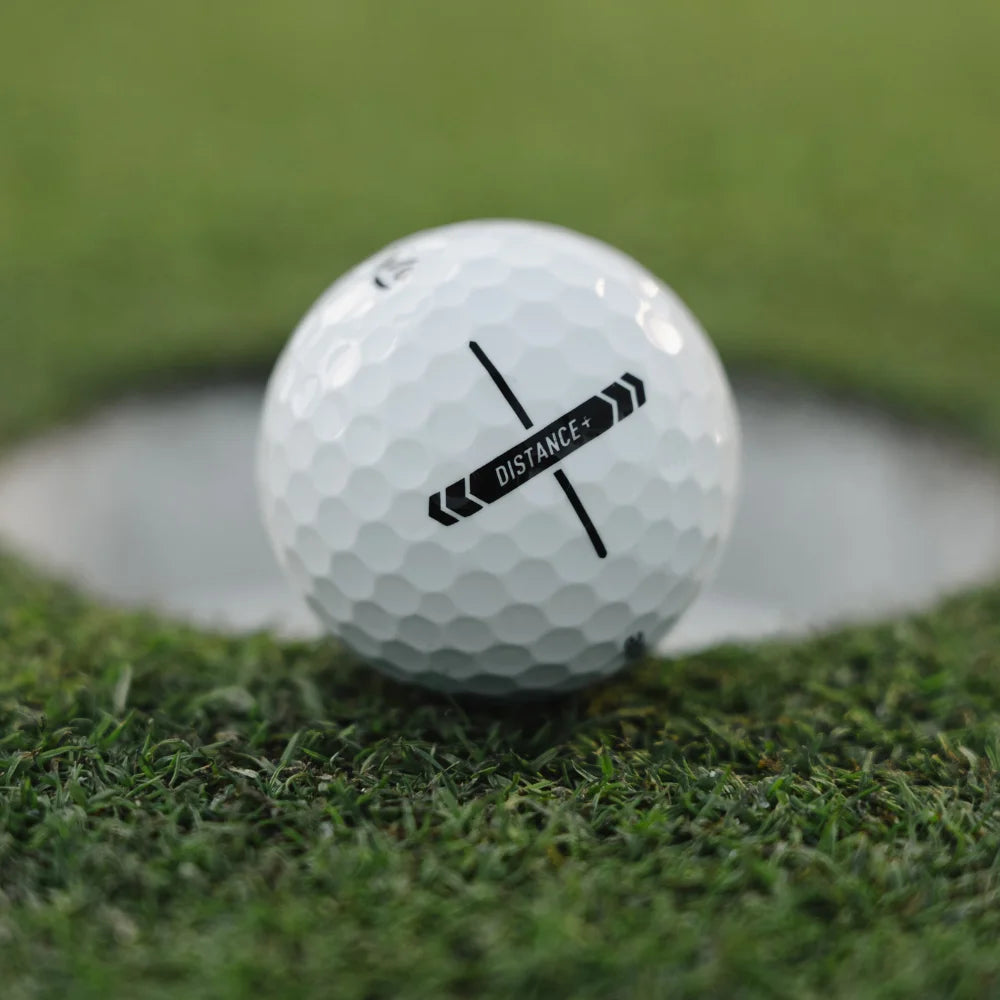 Golf ball with 'Distance' label on grass near a hole