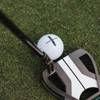 Golf putter and ball on a green grass surface