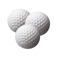 Three white practice golf balls on a white background