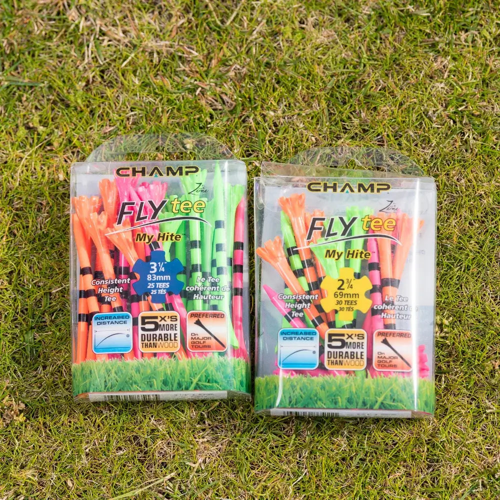 Two packages of golf tees on grass, labeled "champ fly tee," one containing 30 colorful tees with black stripes of 3¼ inches and the other 25 colorful tees with black stripes of 2½ inches, highlighting durability and preferred usage.